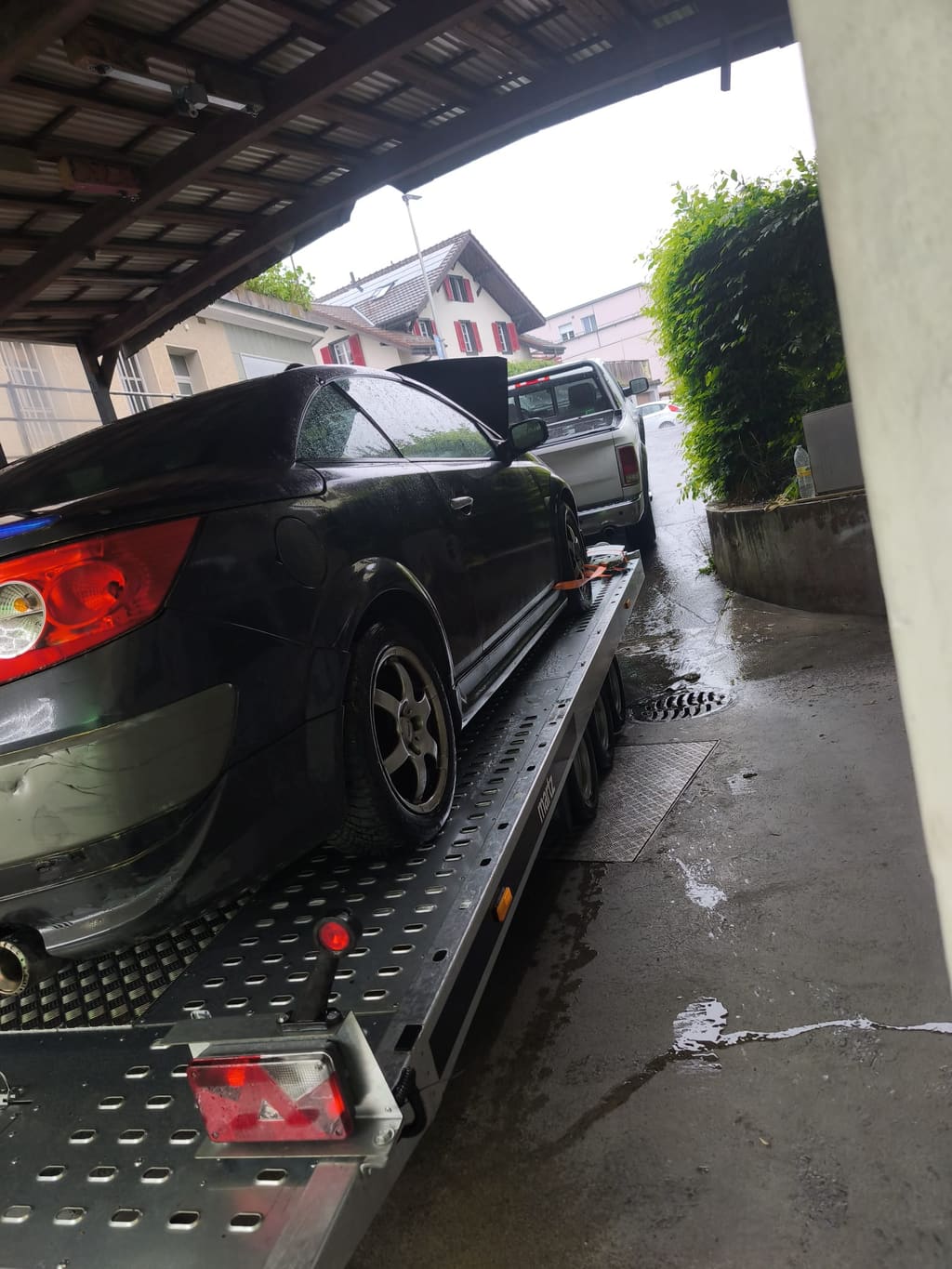 Einsatzfahrzeug von SWISS Abschleppservice in einer engen Einfahrt bei Regen